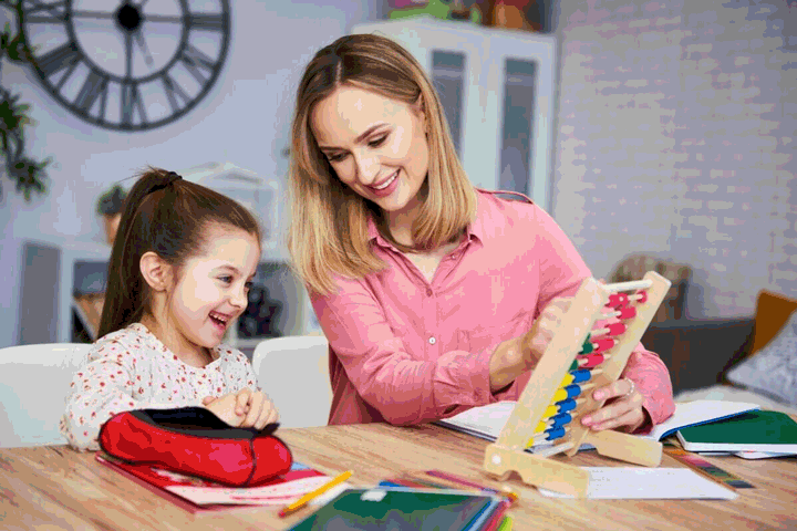 Foto de menina e mãe estudando com ábaco juntas e sorridentes. O apoio é uma forma de trocar o “meu filho não quer estudar” por algo mais positivo.