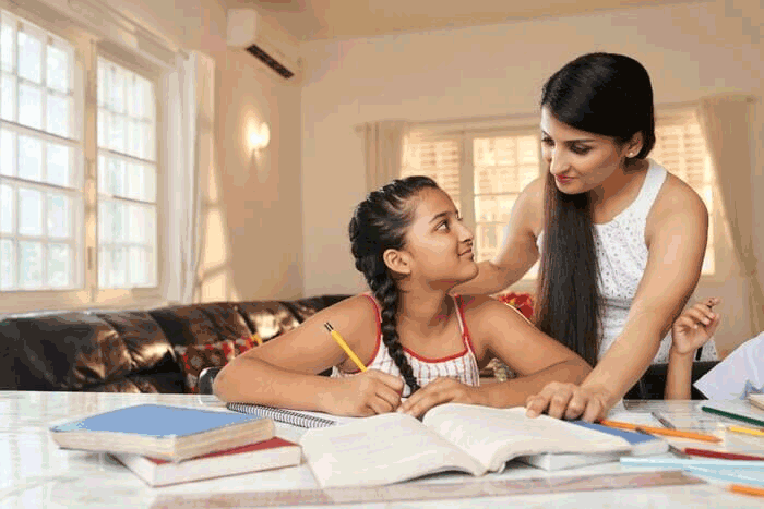 Foto de mãe e filha em meio a materiais de estudo. Para estudar em casa é importante que todos os membros da casa respeitem o horário de estudos.