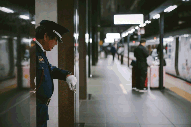  Curiosidades sobre a cultura japonesa: foto de um funcionário da estação de trem olhando o relógio. Pontualidade é um dos costumes dos japoneses.
