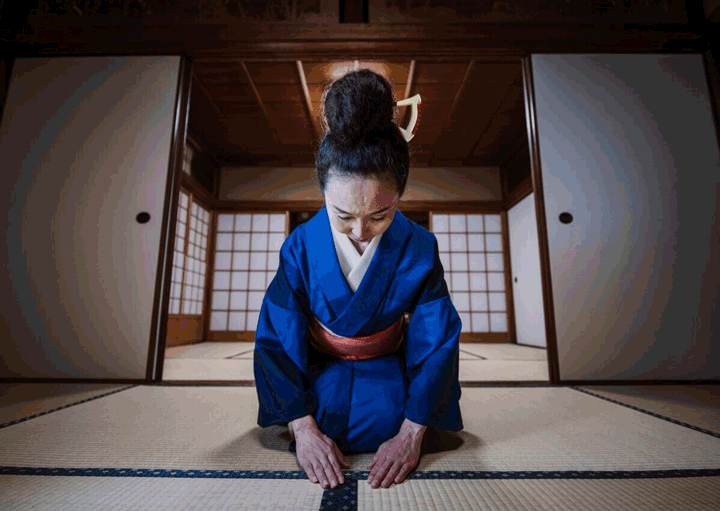  Foto de uma mulher japonesa usando kimono, ajoelhada em um tatame. Muitas curiosidades sobre o Japão envolvem o respeito às tradições.