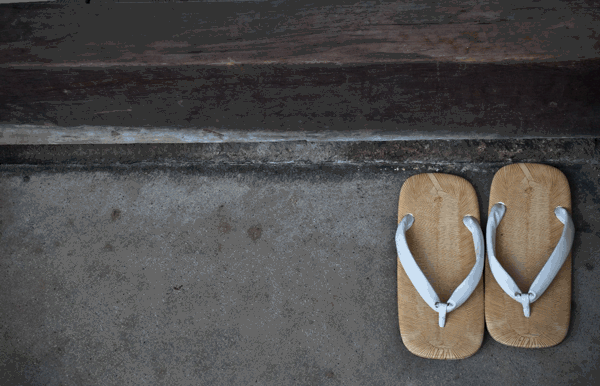 Foto de um par de sandálias no chão. Tirar os calçados para entrar em casa é um dos costumes dos japoneses.