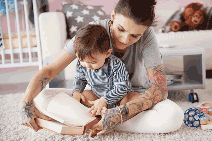Foto de uma mãe lendo para o bebê. Confira algumas dicas de leitura infantil para desenvolver o gosto pelos livros desde cedo.