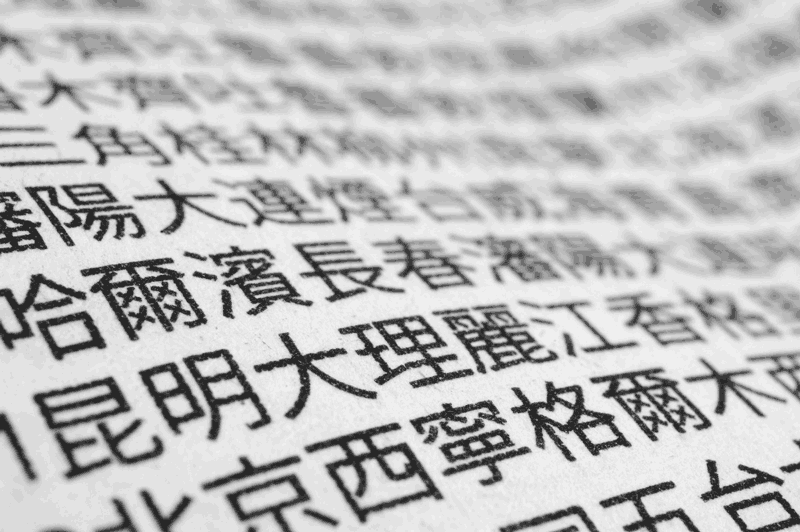 Foto de menino escrevendo em japonês. A diferença entre chinês e japonês é bem grande, mas mesmo assim causa confusão.
